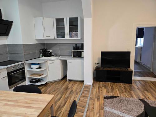 a kitchen with white cabinets and a wooden floor at Monteurwohnungen Lerbachtal in Osterode