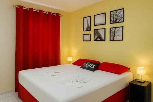 a bedroom with a bed with a red curtain at Yatch Village Flat in Natal