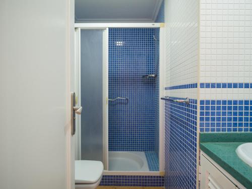 ein blau gefliestes Bad mit einer Dusche und einem WC in der Unterkunft Ciaboga Front Line By CanariasGetaway in San Agustín