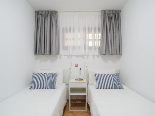 zwei Betten in einem Zimmer mit Fenster in der Unterkunft Ciaboga Front Line By CanariasGetaway in San Agustín