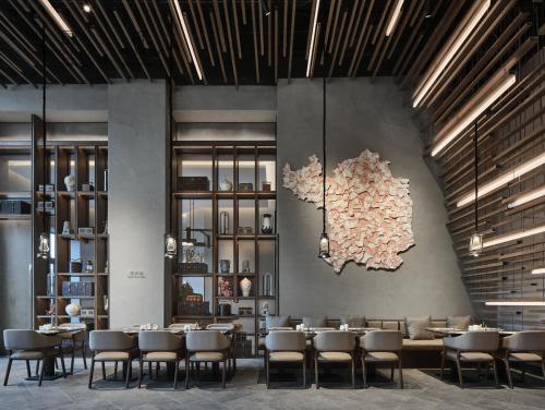 a restaurant with tables and chairs and a map on the wall at Wanda Realm Yan'an in Yan'an