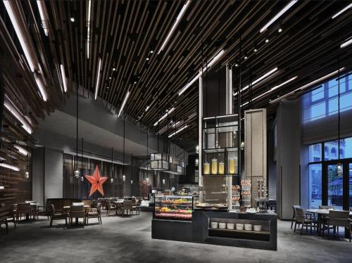a restaurant with tables and chairs and a large ceiling at Wanda Realm Yan'an in Yan'an