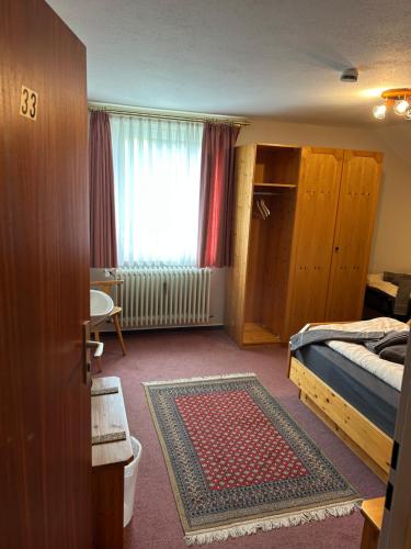 a bedroom with a bed and a window and a rug at Bad Bruckhaus Erlebnishotel in Waldshut-Tiengen