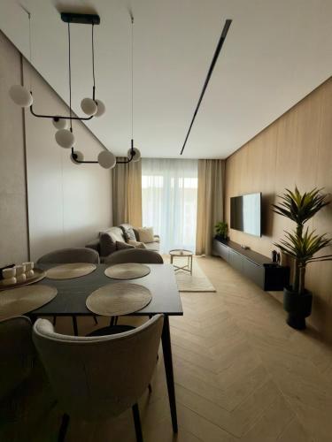 a living room with a table and a couch at SunSet Let`s Sea Baltic Spa in Gąski