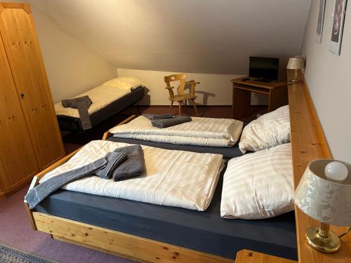a room with three beds and a chair and a desk at Bad Bruckhaus Erlebnishotel in Waldshut-Tiengen