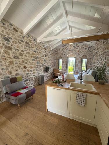 a kitchen with a sink and a stone wall at Mani Stone Studios in Oítilon
