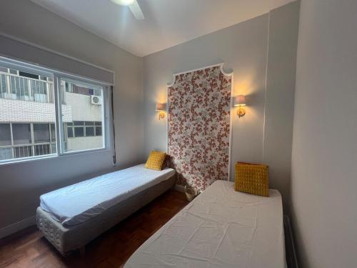 a small bedroom with a bed and a window at Vista Lateral Mar Fique No Melhor Lugar da Praia in São Vicente