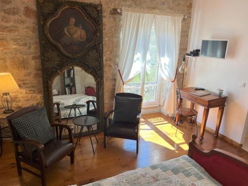 een kamer met een bed, een tafel en stoelen bij Sweet Home Cornelia in Bruniquel