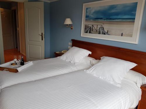 a bedroom with two beds and a picture on the wall at Hotel Faro de San Vicente in San Vicente de la Barquera