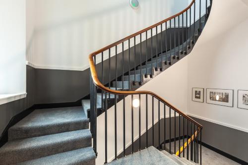 a winding staircase in a home with white walls at Destiny Scotland George IV Apartments in Edinburgh