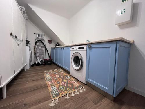 a laundry room with a washing machine and a rug at Perquilhas House in Freixial do Campo