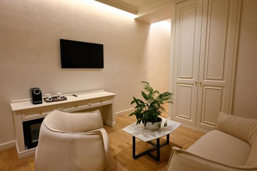 a living room with two chairs and a tv at King & Queen Boutique Hotel in Fier