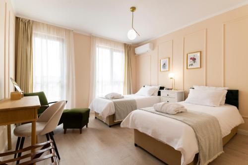 a hotel room with two beds and a desk at 21 Villa Vitosha Romantic Getaway in Hisarya