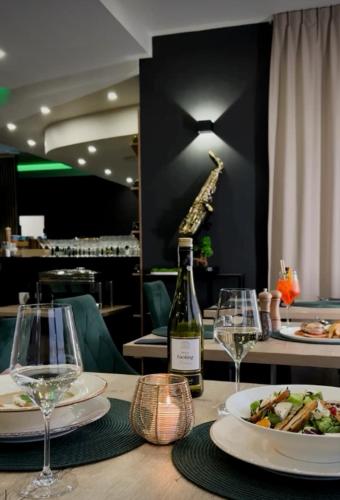 a table with a bottle of wine and a giraffe on a wall at Hotel CARO in Poznań