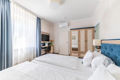 a bedroom with a white bed and a window at Strandhotel Löchnerhaus in Reichenau