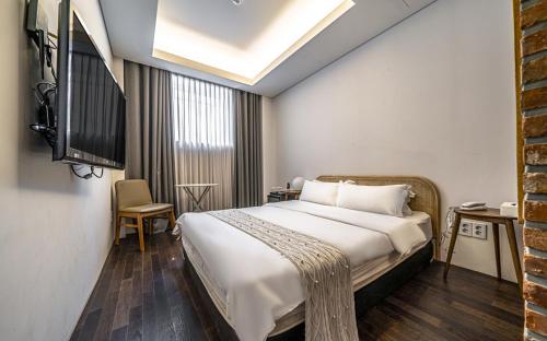 a bedroom with a large bed and a television at 케일라호텔 in Uijeongbu