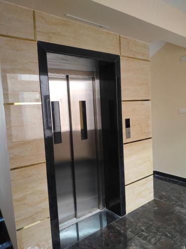 a elevator in a room with a wooden wall at SaiNivas Satyam in Chennai