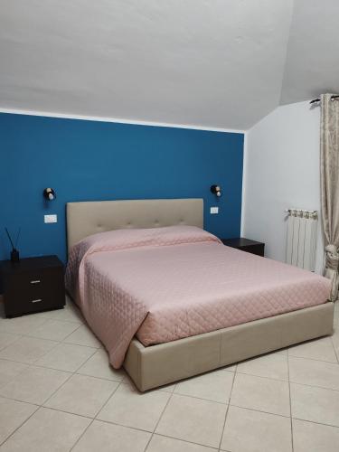 a bedroom with a bed with a blue wall at Belo Horizonte Loft in Montesilvano