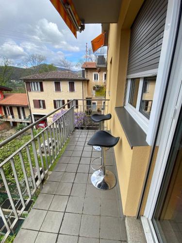 a balcony with two stools on the side of a building at Monte Verde Lugano App in Cadro