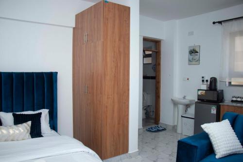 a bedroom with a large wooden cabinet next to a bed at Adristar Homes Ruiru Membley in Ruiru