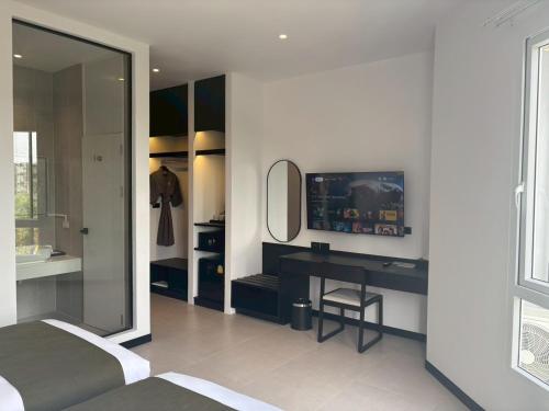 a bedroom with a bed and a desk and a mirror at Hotel Whitt Hua Hin in Hua Hin