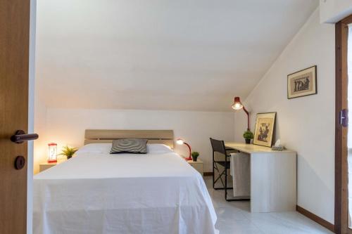a bedroom with a white bed and a desk at Italian Experience-Villa Monte Gabberi in Pietrasanta