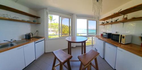 a kitchen with a table and chairs and a window at F1 vue mer, accès plage, en centre-ville in Le Gosier