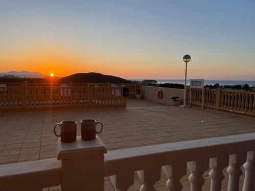 a sunset from a balcony with two mugs at Bol02 - Modern 2 bedroom apartment in Bolnuevo in Bolnuevo