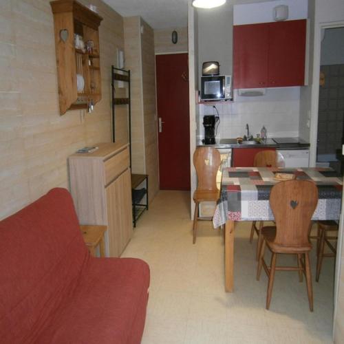 une cuisine et un salon avec une table et des chaises dans l'établissement Appartement Le Relais Du Devoluy, à Saint-Étienne-en-Dévoluy