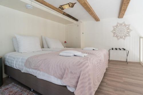a white bedroom with a large bed with white pillows at 1001 Nights Boutique Lofts in Haarlem