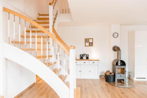 a staircase in a home with white walls and wood floors at Huxfeld-Hof - Wümme in Grasberg