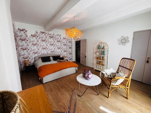 a bedroom with a bed and a table and chairs at Le Beldi, Mas de Village 1870 in Saint-Saturnin-lès-Avignon