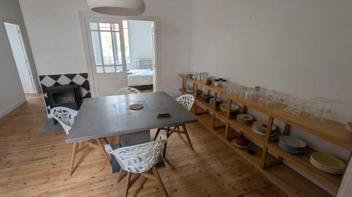 une salle à manger avec une table et des chaises et une cheminée dans l'établissement Maison calme avec terasse proche centre ville, à La Rochelle