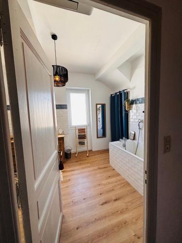 a bathroom with a white door and a bath tub at Le Beldi, Mas de Village 1870 in Saint-Saturnin-lès-Avignon