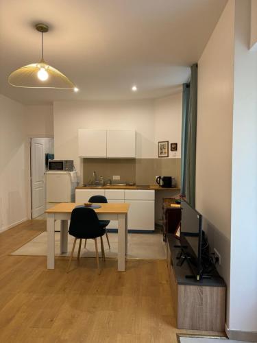 une cuisine et une salle à manger avec une table et des chaises dans l'établissement Appartement meublé tout confort, à Chalon-sur-Saône