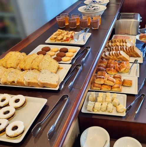 a buffet line with different types of pastries and donuts at StradivariuS Hotel Boutique in Villa General Belgrano