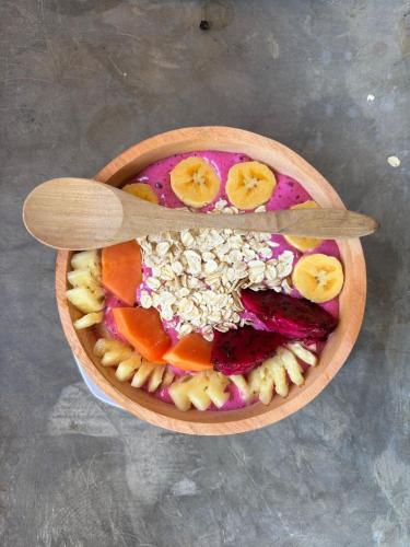 Castaway Island Hostel في نوسا ليمبونغان: وعاء من المعكرونة والفواكه مع سكين