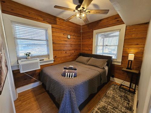 a bedroom with a bed in a room with wooden walls at Cozy Cabin, Foliage, Hot Tub, Wi Fi, Fireplace in Mars Hill