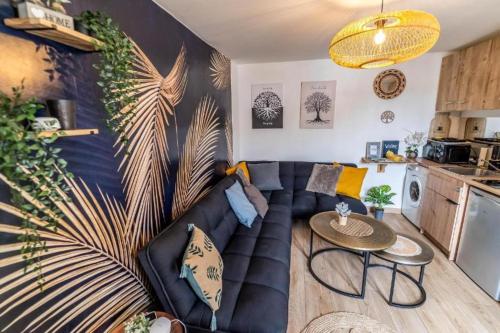 un salon avec un canapé et une table dans l'établissement JUNGLE Appart 2 chambres parking 10min port Honfleur et plage, à Honfleur