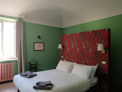 a bedroom with a large bed with a red headboard at VILLA ADRIANA in Bra