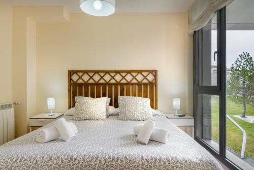 a bedroom with a large bed with white pillows at Duplex Las Margas Vistas Montañas in Sabiñánigo
