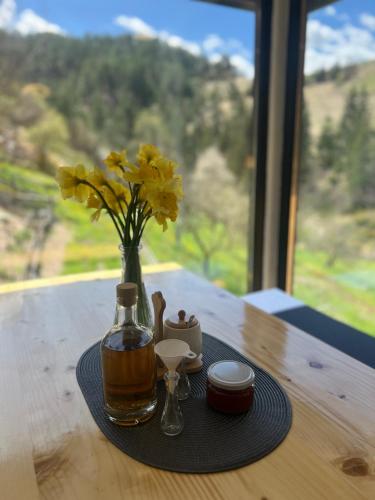 a table with a vase with yellow flowers in it at Planinska koliba Dada in Popovići