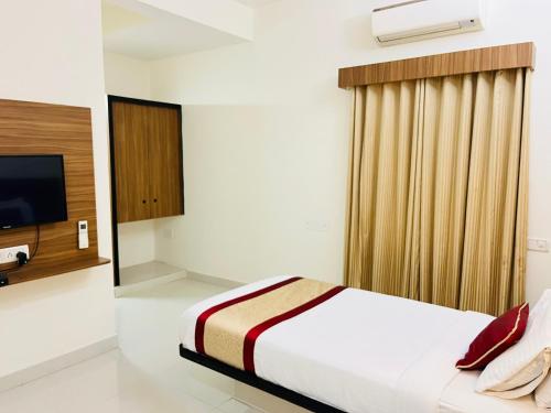 a hotel room with a bed and a television at Hotel Grand Bee , Yeshwanthpur Junction in Bengaluru