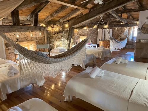 een kamer met meerdere bedden en hangmatten bij Sweet Home Cornelia in Bruniquel