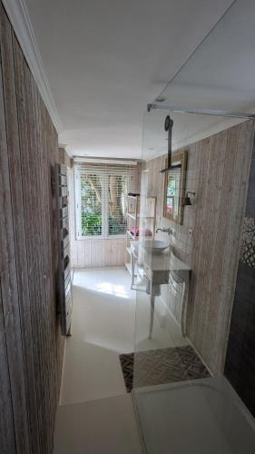 une salle de bain avec un lavabo et un bureau dans une chambre dans l'établissement Maison calme avec terasse proche centre ville, à La Rochelle