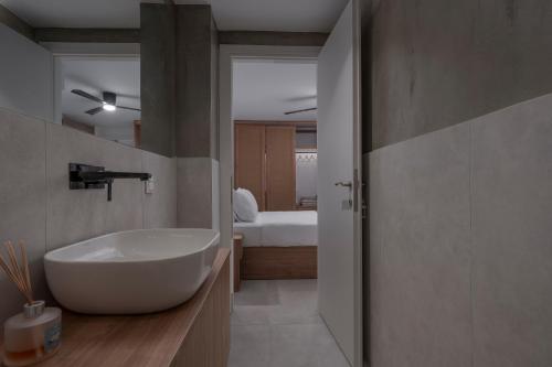een badkamer met een witte wastafel en een slaapkamer bij Blue Haven Villa in Polykhrono