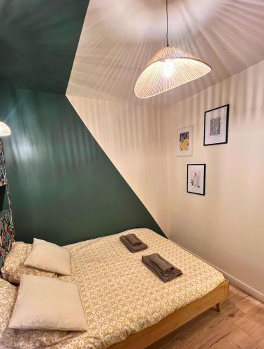 a bed in a room with a green wall at Le secret du Damier by Miss K in Mâcon