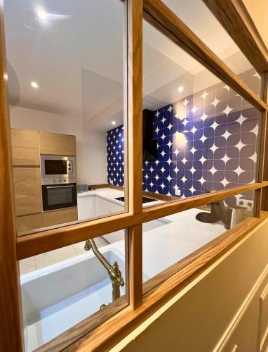 a kitchen with a window and a microwave at Le secret du Damier by Miss K in Mâcon