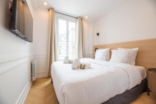 une chambre d'hôtel avec deux lits et une télévision dans l'établissement 1 Bedroom Flat - Crémieux, Bastille, à Paris