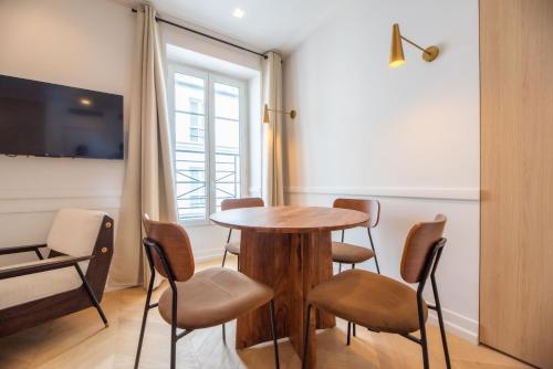 une pièce avec une table, des chaises et une fenêtre dans l'établissement 1 Bedroom Flat - Crémieux, Bastille, à Paris